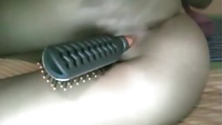 Brunette girl masturbates closeup with a hairbrush