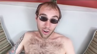 A hairy dude in sunglasses strokes his dick with two hands