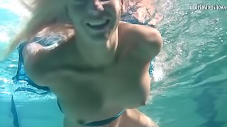 Blonde with natural tits displaying pussy while swimming