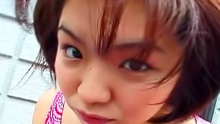 Smiling Asian chick is giving a deep blowjob